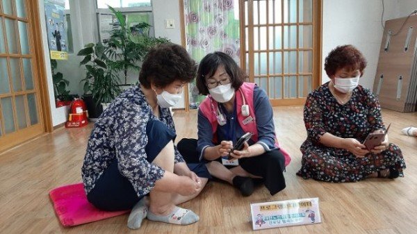 영주 2-경로당행복도우미가 어르신들에게 스마트폰 사용법을 설명하고 있다.(1).jpg