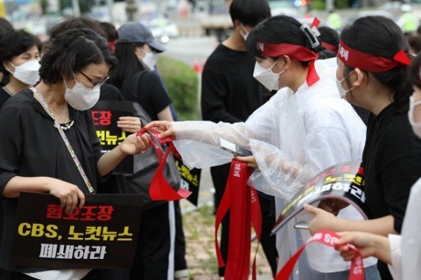 성도들이 행사 시작 전 머리띠를 서로 묶어 주고 있다..jpg