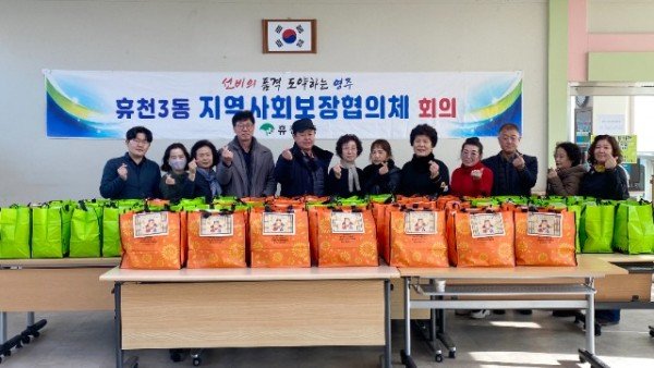 휴천3동 지역사회보장협의체회원들이 설명절 꾸러미 와 함께 단체기념촬영을 하고있다..jpg