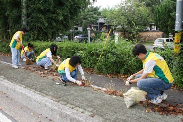 1_신천지자원봉사단_경주지부_봉사자들이_불국사_일원_산죽한옥마을_도로변_환경_정화를_위해_잡초제거와_낙엽을_수거하고_있다.jpg