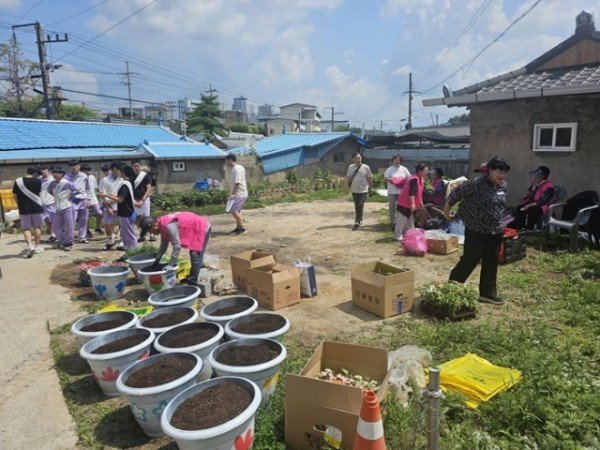 영주-1-2 참가자들이 마을 분위기를 화사하기 조성하기 위한 꽃화분을 준비하고 있다 (1).jpg